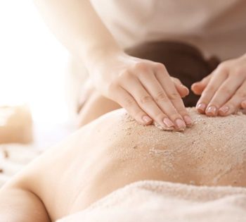 pessoa deitada de costas fazendo esfoliação corporal no Buddha Spa